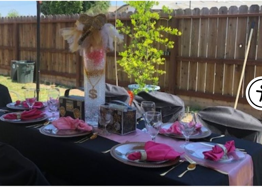 Backyard money-themed table setting with pink napkins